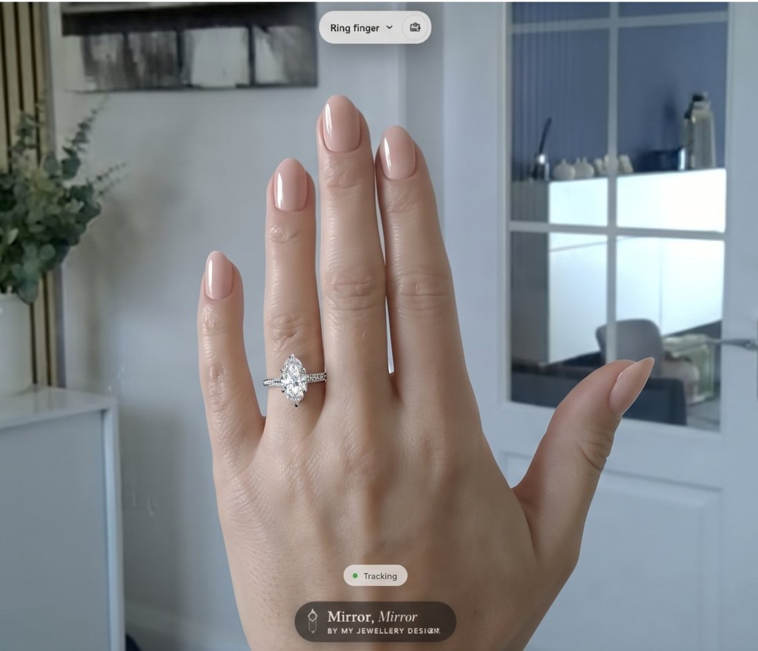 A client's live camera view with a marquise diamond engagement ring placed on her ring finger by Mirror, Mirror